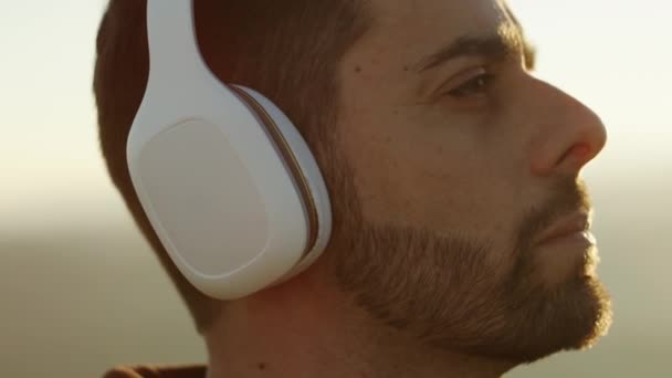 Homme écouter de la musique dans les écouteurs en plein air — Video