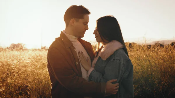 Pareja abrazos unos a otros en la luz del atardecer —  Fotos de Stock