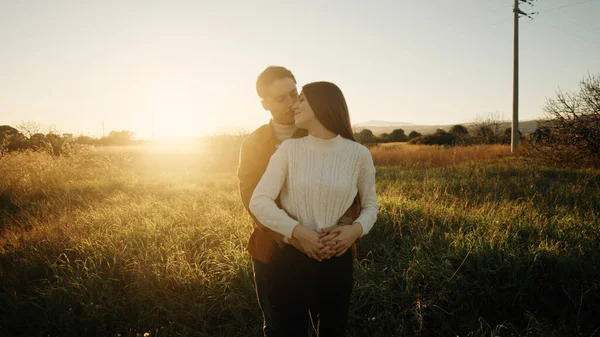 Romantik çift gün batımında dışarıda kucaklaşıyor. — Stok fotoğraf