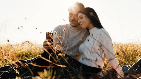 Verlobtes Paar schaut aufs Handy. — Stockfoto