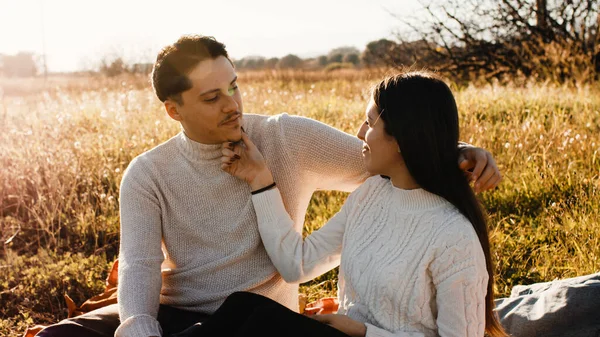 Casal apaixonado em um campo ao pôr do sol — Fotografia de Stock