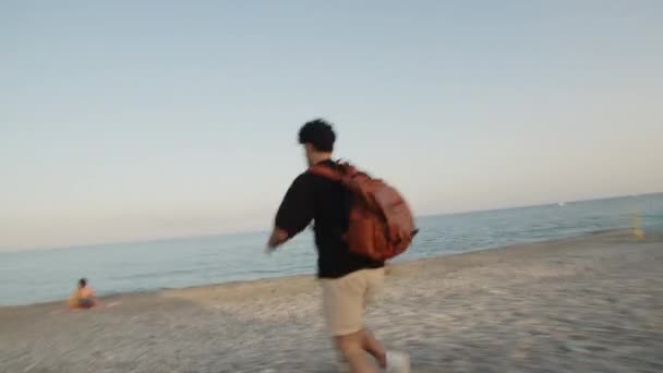 Αγόρι με σακίδιο τρέχει στην παραλία — Αρχείο Βίντεο