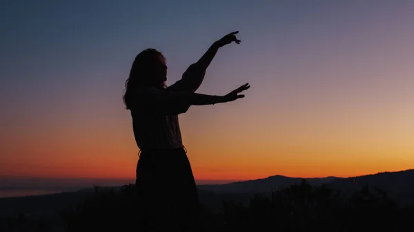 Silhouette eines sorglos tanzenden Mädchens bei Sonnenuntergang — Stockfoto