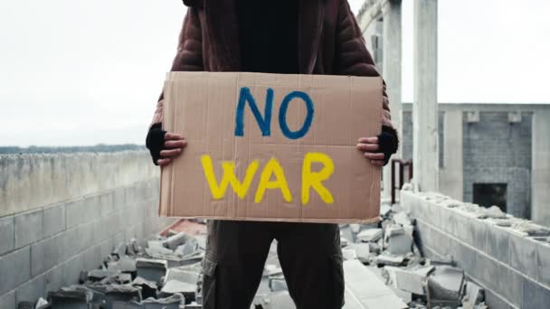 Ukrainian boy holding an anti-war placard in his hand — Stock Video