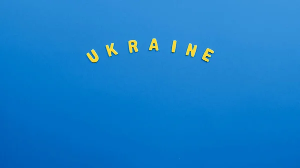 Žluté ukrajinské písmo na modrém pozadí. Konflikt Ukrajiny — Stock fotografie