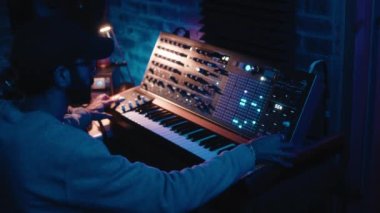 Synthesizer üzerinde çalışan müzik yapımcısını kapat