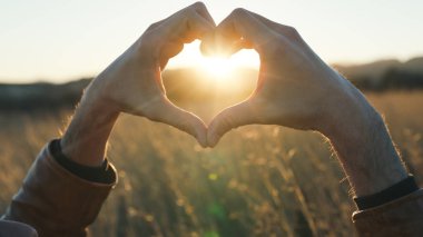 Gün batımında Eller Kalp Şeklinde Kapat