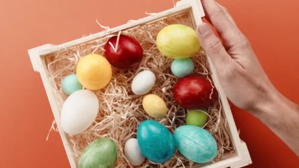 Mano con cesta de huevos de Pascua pintados sale — Vídeo de stock