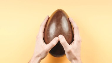 Sarı arka planda bir paskalya yumurtası açmak 