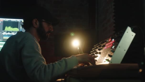 Nahaufnahme eines Musikproduzenten, der am Synthesizer arbeitet — Stockvideo