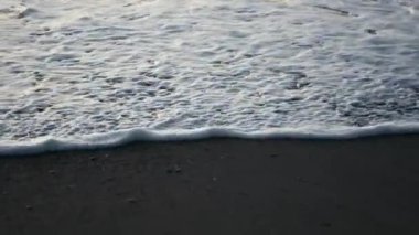 Sabahın erken saatlerinde kumlu sahilde okyanus köpüğü 