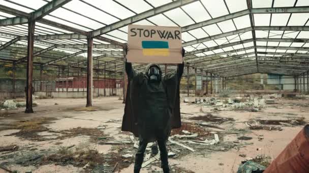 Holding a stop war placard in in a bombed area — Stock Video
