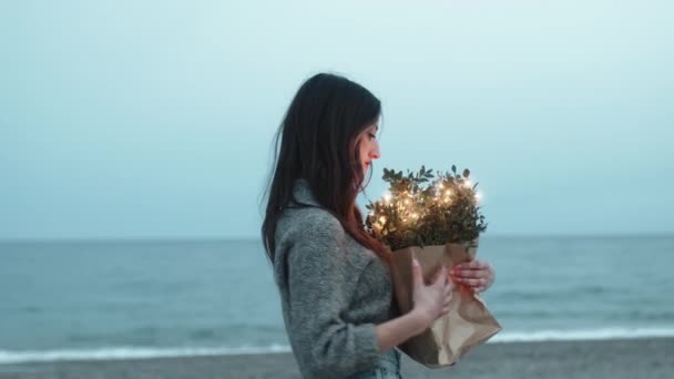 Chica en la playa con una bolsa de compras de luces — Vídeo de stock