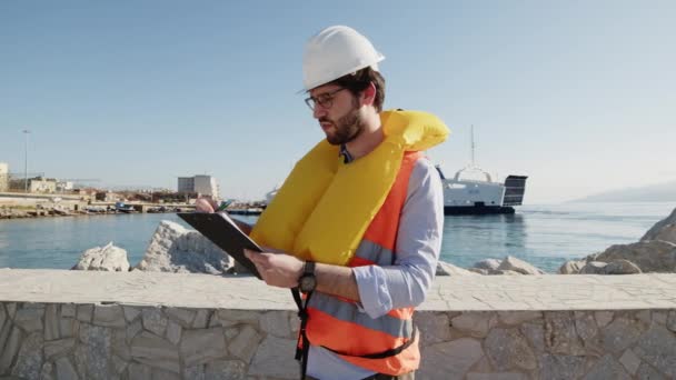 Engineer takes notes on a clipboard — Vídeo de stock