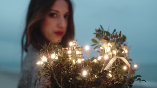 Sweet girl squeezes to herself bouquet of flowers with lights — Stock video