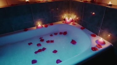 Romantik kokulu mumlar ve yapraklarla dolu bir küvet.