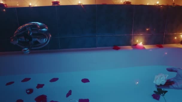 Wanna z romantycznymi świecami zapachowymi i płatkami — Wideo stockowe