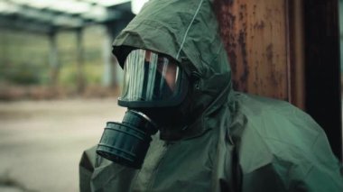 Soldier with gas mask is resting on the ground