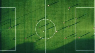 Football match on green field at sunset light 
