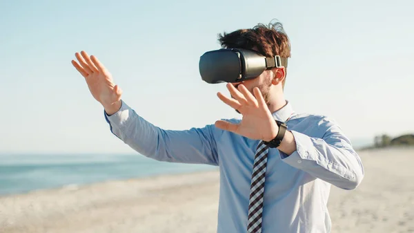 Empresário com visualizador de realidade aumentada em praia metaversa — Fotografia de Stock