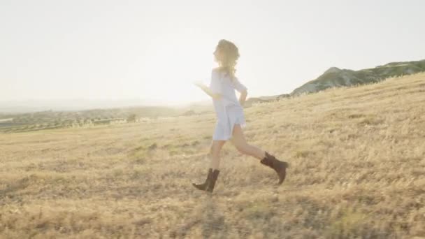 Ευτυχισμένο κορίτσι τρέχει σε ένα χωράφι — Αρχείο Βίντεο