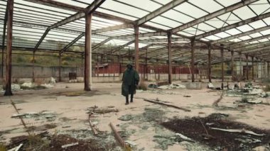 man with gas mask walks in an abandoned place