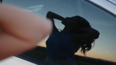 Bir arabanın camına yansıyan kıza yaklaş.