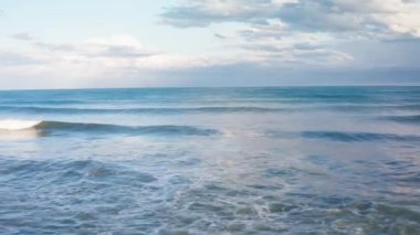 Okyanus dalgalarının kumlu sahile çarpması.