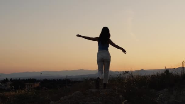 Κορίτσι Περπατά Ανοιχτές Αγκάλες Στο Ηλιοβασίλεμα — Αρχείο Βίντεο