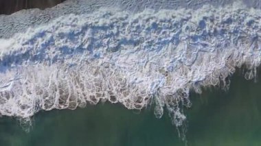 Okyanus dalgalarının kumlu sahile çarpması.