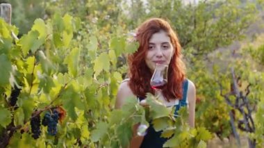 Close up of happy girl with glass in the vineyard