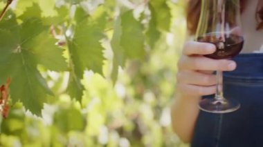 Girl with Goblet of red wine near bunch of grapes. 