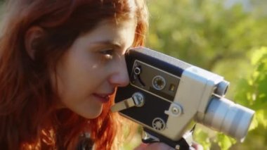 Close up of a happy girl with a vintage super8 cinema camera 