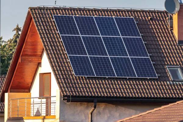 Solar photovoltaic panels on the roof of a family house, with a balcony.