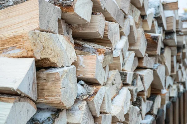 Depodaki odunlara ya da karla kaplı bir ahıra yakın çekim. Sokakta bir sürü tahta kütük var. Şömine için odun kestim. Şehir dışında ya da kırsal kesimde..