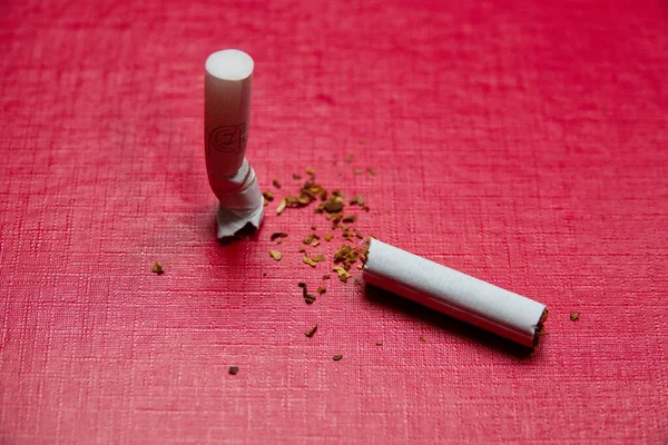 赤い背景の壊れたタバコ. — ストック写真