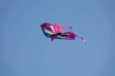 Mavi gökyüzünde uçan renkli uçurtma