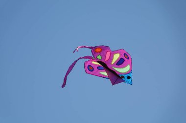 Mavi gökyüzünde uçan renkli uçurtma