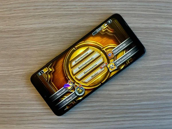 Prag, Tschechien - 1. März 2022: Ein Smartphone mit einem Hearthstone-Spiel liegt auf einem Holztisch. — Stockfoto