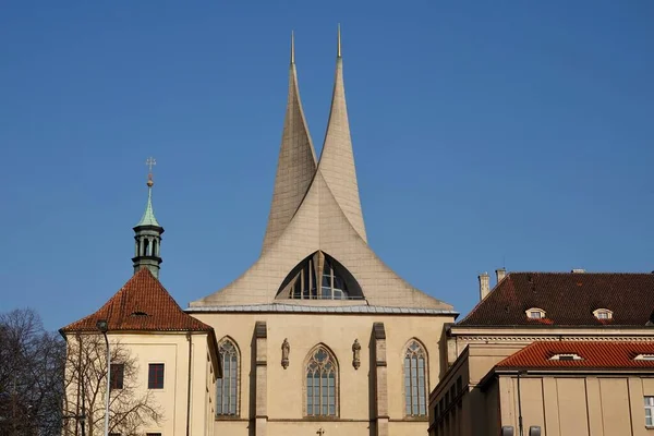 Benedictine monastery Emauzy, frontal view. Architectural monument from fourteen century with two modern spiky towers on sunny day in Prague — Stock fotografie