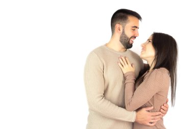 Couple in love looking at each other and smiling while embracing affectionately.