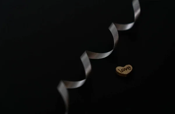 Silver Ribbon Wooden Heart Word Love Black Background — стоковое фото