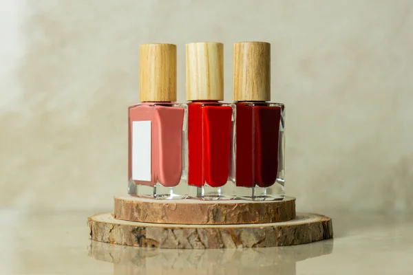 Tahtanın üzerinde üç kırmızı ve pembe oje rengi var.