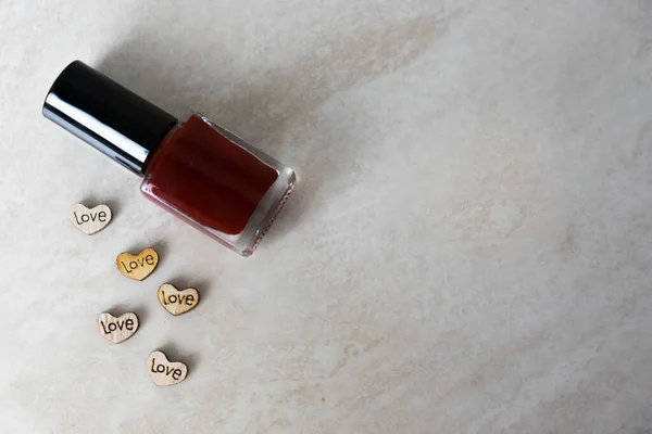 Kırmızı kapalı ojeli bir arka plan ve üzerinde 