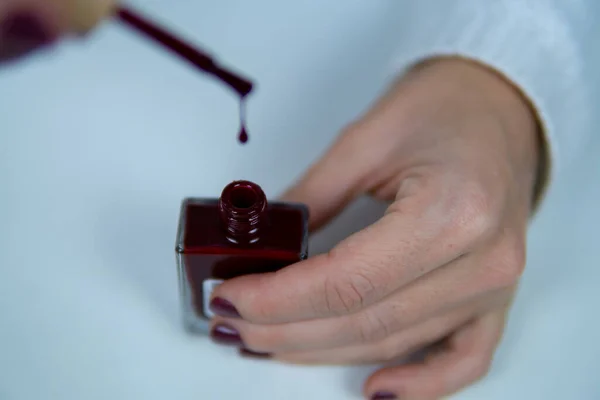 Bir kadının elleri oje tutarken ve ojeleri düşerken odağından fırçalarken..