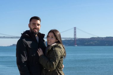 Lizbon, Portekiz 'de 25 Nisan köprüsünün yanında poz veren çift.