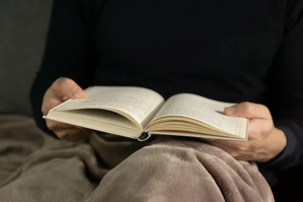 Elinde kitap tutan tanınmayan genç bir adam.