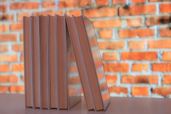 Tuğla zemin kaplamalı bir kitap rafına dizilmiş kitaplar