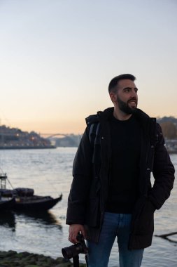 Elinde kamerayla gün batımında Porto 'yu ziyaret eden fotoğrafçı.