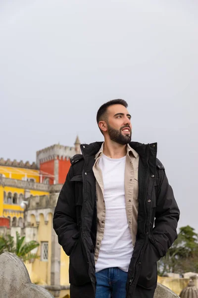 Yan tarafa bakan genç erkek turist Sintra 'daki Palace da Pena' yı ziyaret ediyor.
